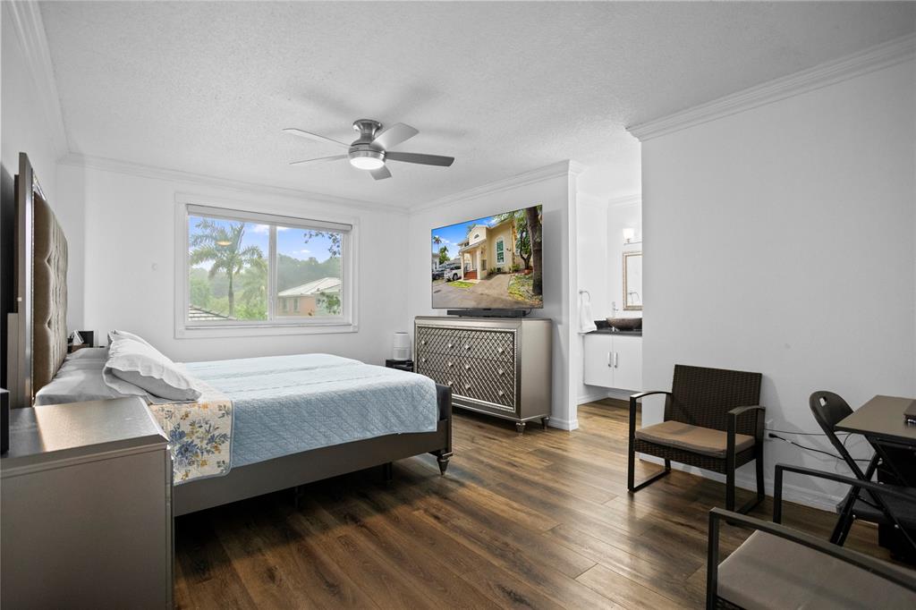 9837 Northwest 2nd Court Plantation, FL 33324 - Photo 38 of 69 a bedroom with a bed wooden floor and a desk