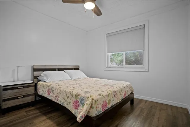 a view of a house with a small yard and large trees