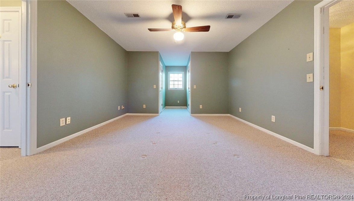 1132 North Moore Road Robbins, NC 27325 - Photo 29 of 50 an empty room with a chandelier fan and windows