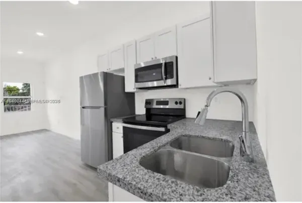 a kitchen with stainless steel appliances white cabinets and a refrigerator