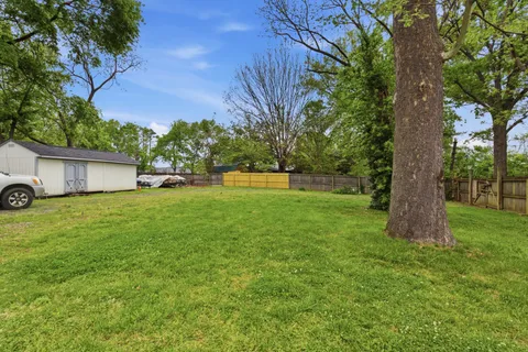 a front view of house with a garden and trees