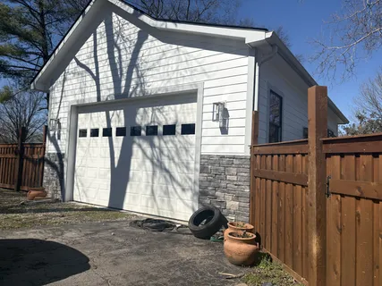 a view of a house with backyard and wooden fence