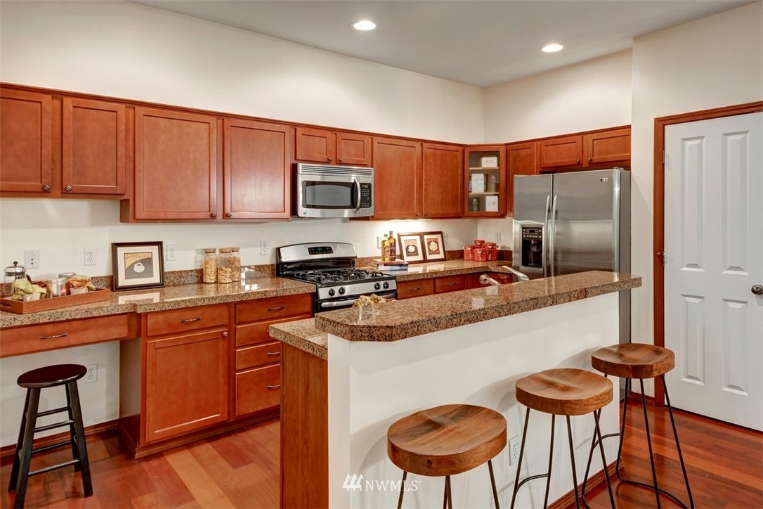 21622 11th Court Southeast Bothell, WA 98021 - Photo 7 of 19 a kitchen with stainless steel appliances granite countertop a stove a sink a microwave a refrigerator and chairs