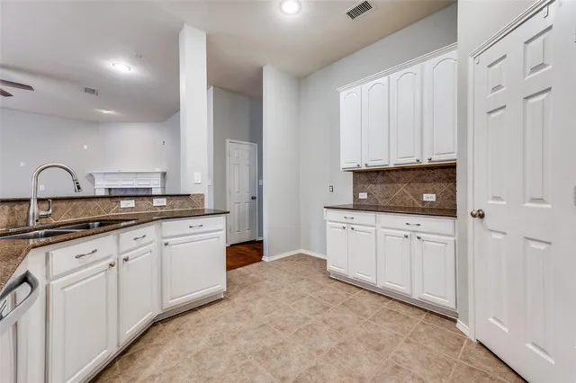 a kitchen with granite countertop white cabinets and stainless steel appliances