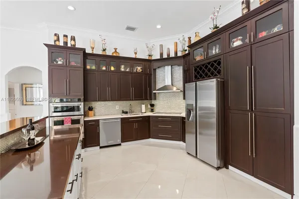 a large kitchen with kitchen island a sink stainless steel appliances and cabinets