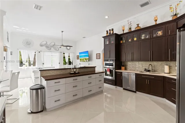 a living room with furniture kitchen view and a wooden floor