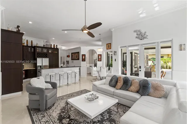 a dining room with wooden floor a chandelier a flat screen tv and a chandelier
