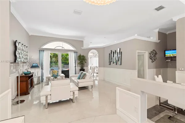 a dining room with furniture a chandelier and wooden floor