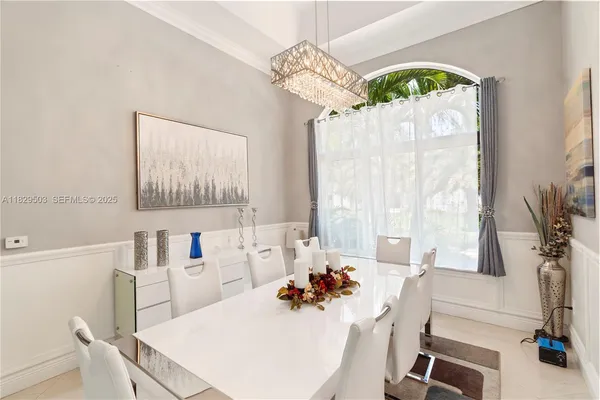 a very nice looking dining room with a large mirror a dining table and chairs