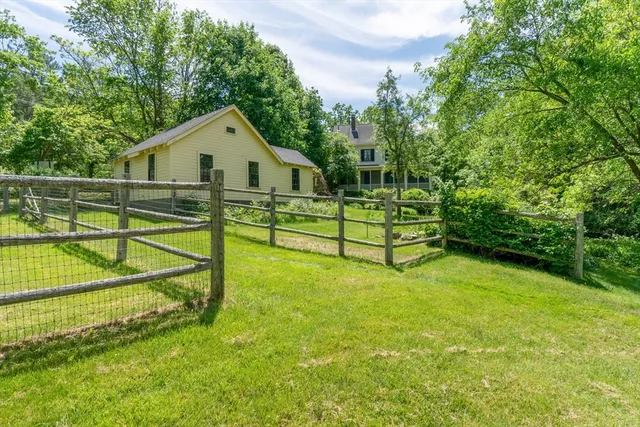 a view of backyard with swimming pool and bench