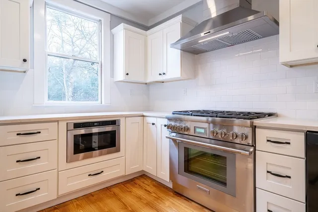a kitchen with stainless steel appliances white cabinets and a stove