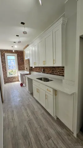 a kitchen with stainless steel appliances a sink cabinets and wooden floor