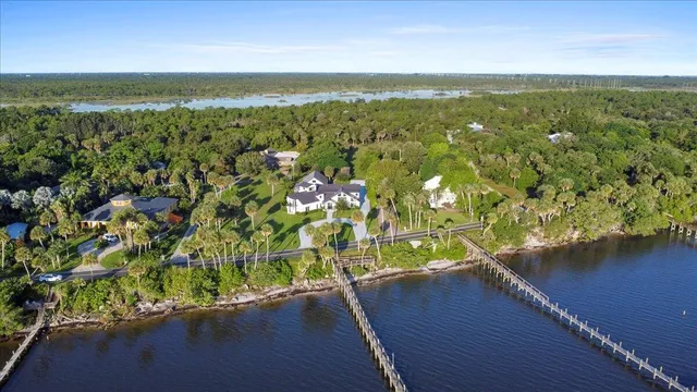 an aerial view of residential houses with outdoor space and lake view