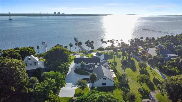 an aerial view of a house with a yard and lake view