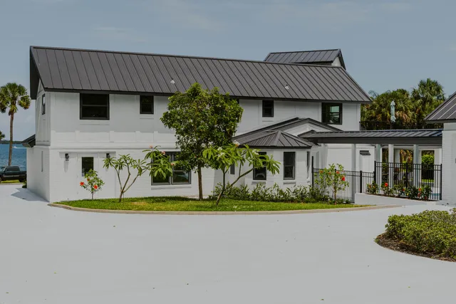 a front view of a house with a garden and plants