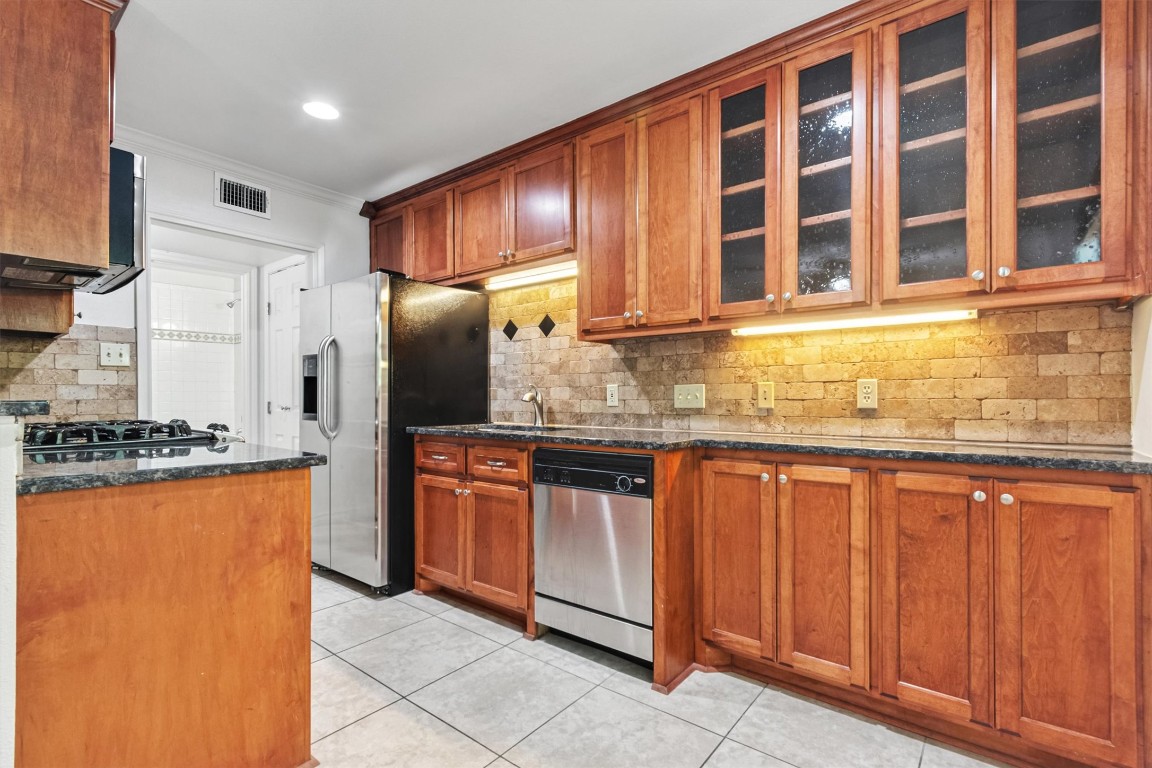 407 East 45th Street, Unit 111 Austin, TX 78751 - Photo 8 of 15 a kitchen with stainless steel appliances granite countertop a refrigerator and a stove top oven