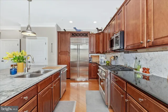 a kitchen with stainless steel appliances granite countertop a sink a stove and a refrigerator