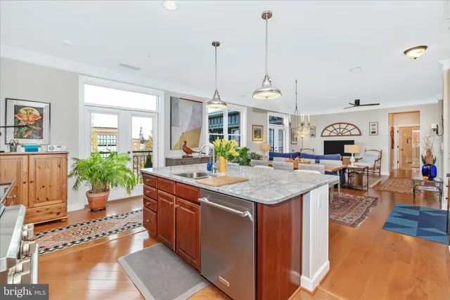 a kitchen with stainless steel appliances granite countertop a stove a sink dishwasher and a dining table with the living room view