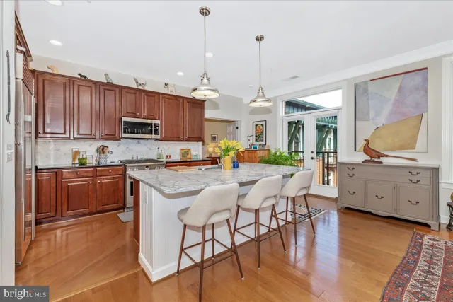 a kitchen with stainless steel appliances kitchen island granite countertop a stove a sink a center island and a cabinets