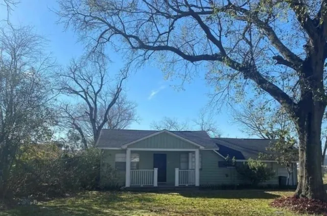 a front view of a house with a garden