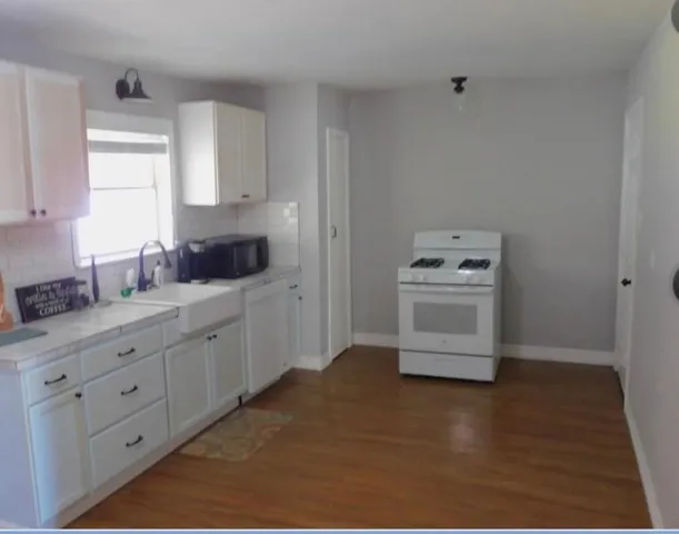 a kitchen with cabinets stove and sink