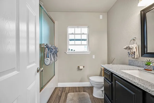 a view of a dining room with furniture a rug and wooden floor