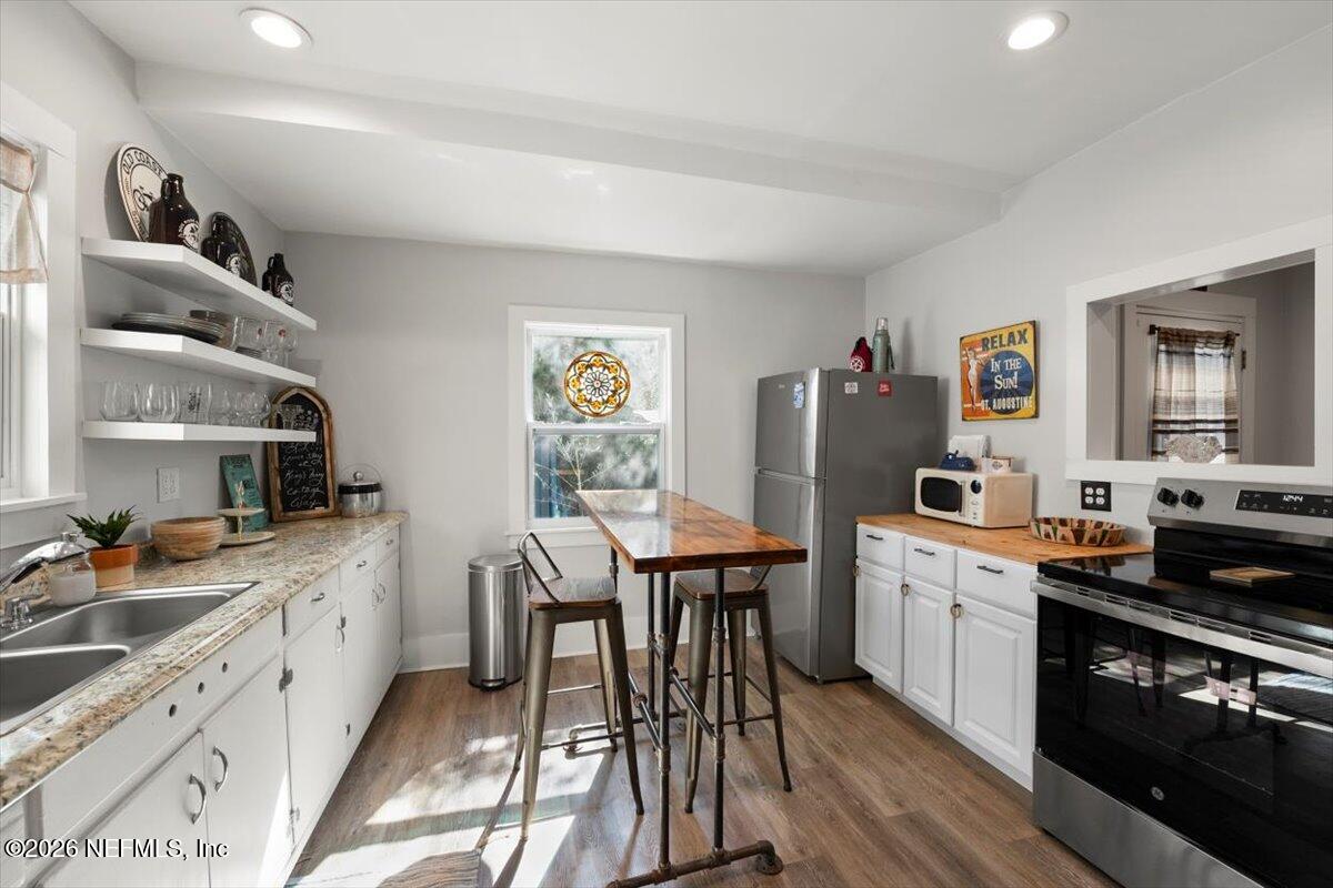 71 Kings Ferry Way St. Augustine, FL 32084 - Photo 11 of 33 a kitchen with stainless steel appliances granite countertop a stove a sink dishwasher and cabinets with wooden floor