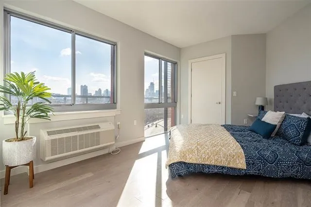a bedroom with a bed and a potted plant on the dresser