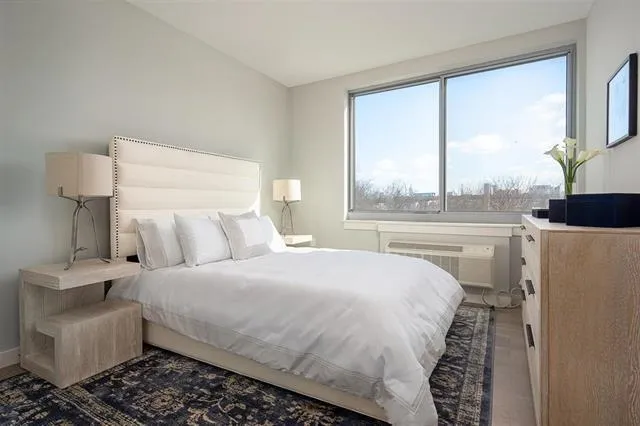 a bedroom with a bed and a large window