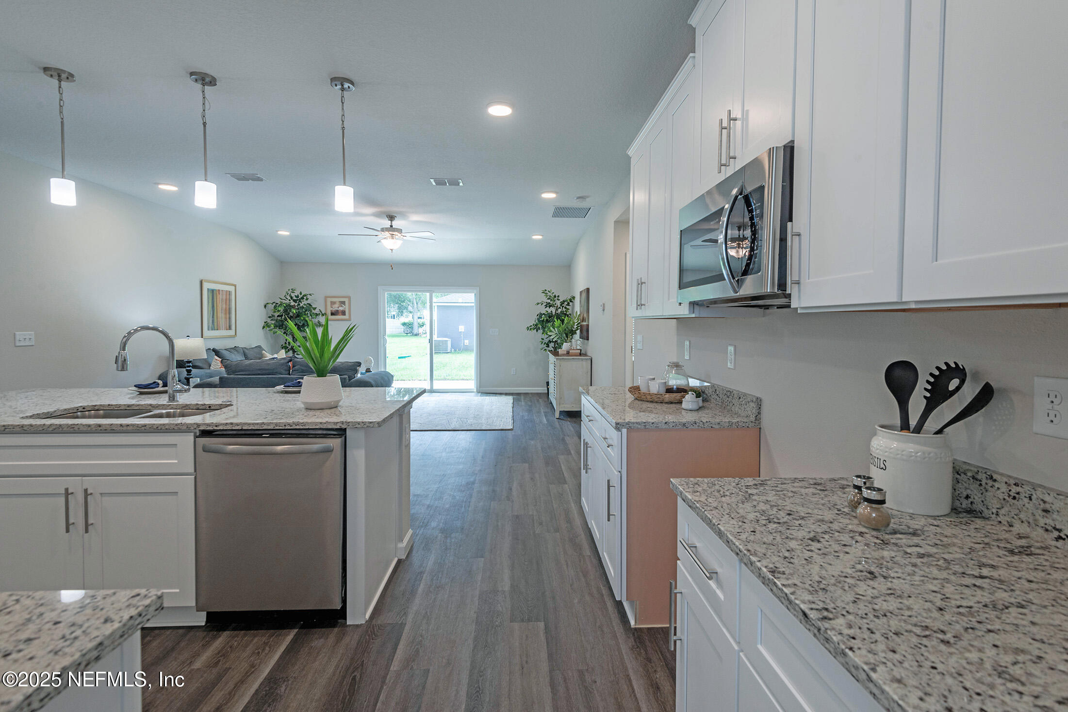 8784 Orme Road Jacksonville, FL 32220 - Photo 10 of 45 a kitchen with a sink dishwasher a stove and white cabinets with wooden floor