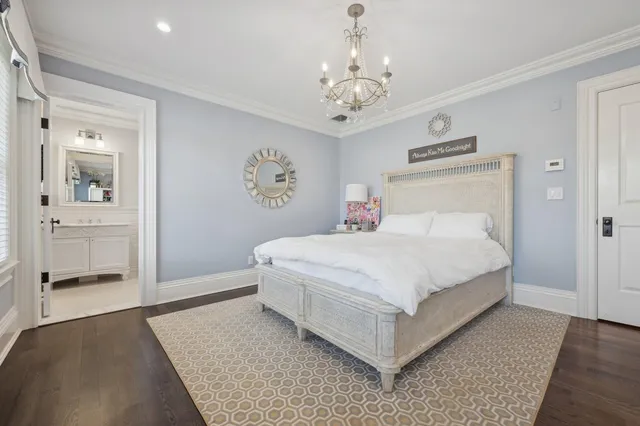 a bedroom with a large bed and a chandelier