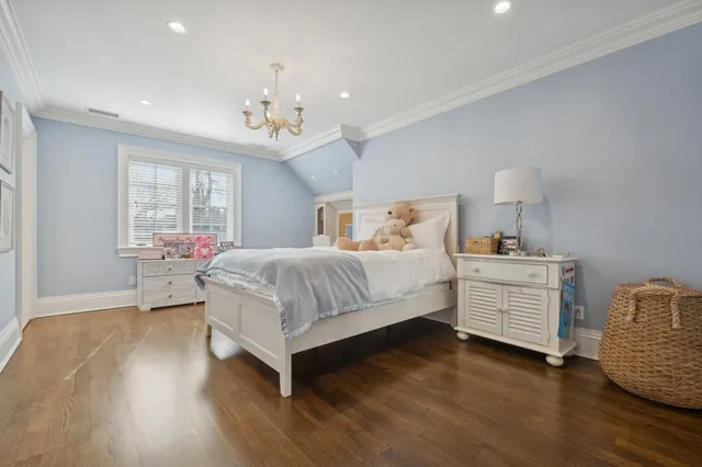 a bedroom with a bed chandelier and a window