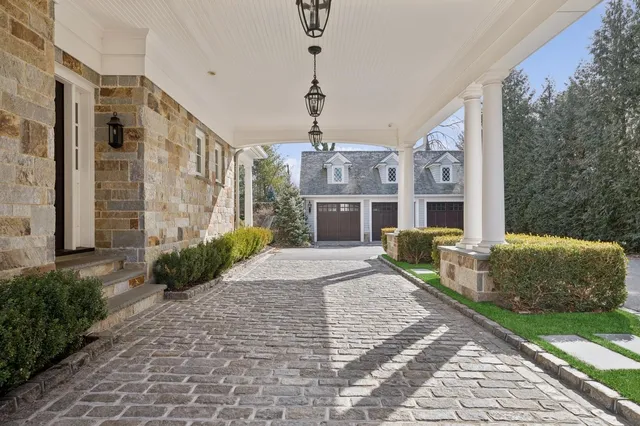 a front view of a house with a garden and trees