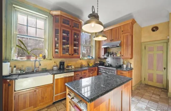 a kitchen with stainless steel appliances granite countertop a sink a stove and a refrigerator