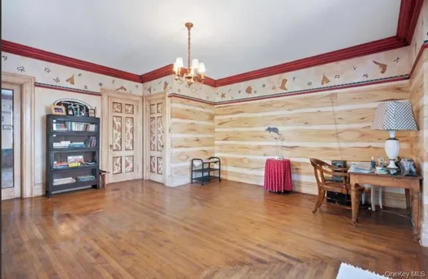 a front view of a room with stainless steel appliances wooden floor and dining table