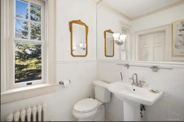 a bathroom with a toilet sink and mirror
