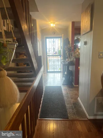 a view of entryway and hall with wooden floor