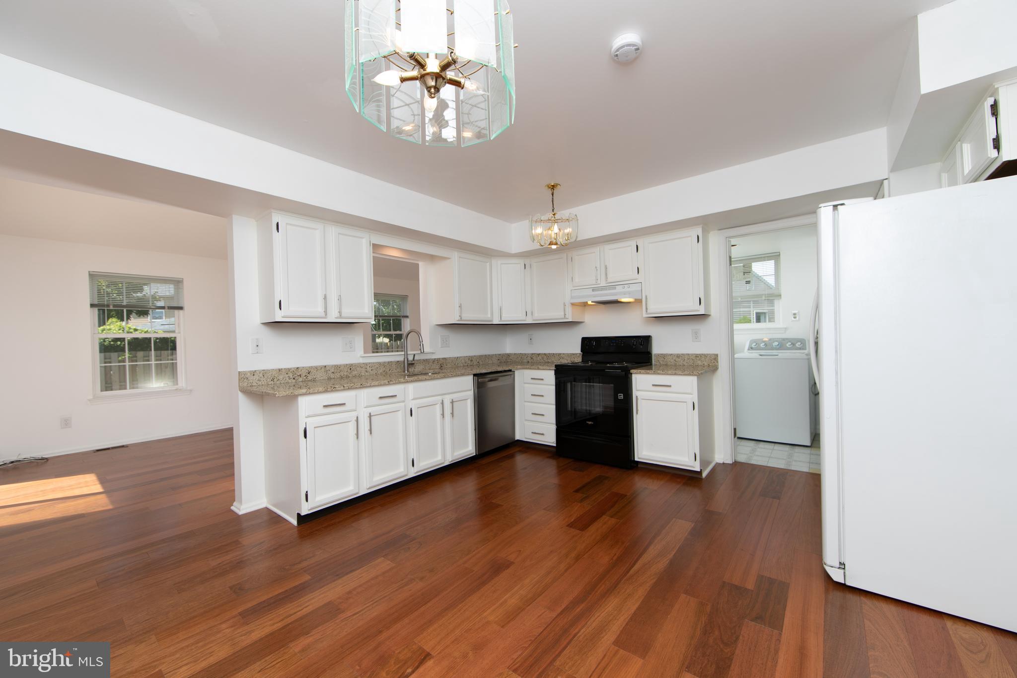 3007 Rampart Road Bensalem, PA 19020 - Photo 13 of 48 a kitchen with wooden floors and white cabinets