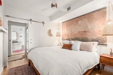 a bedroom with a bed and wooden floor