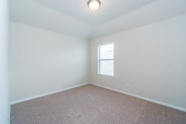 an empty room with a window and a mirror