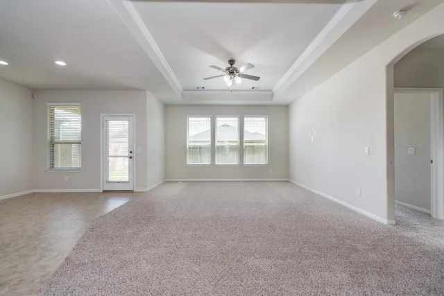 en empty room with windows and chandelier