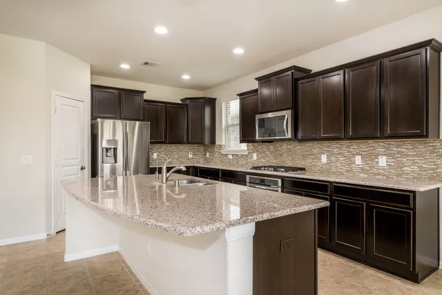 a kitchen with kitchen island granite countertop stainless steel appliances and cabinets