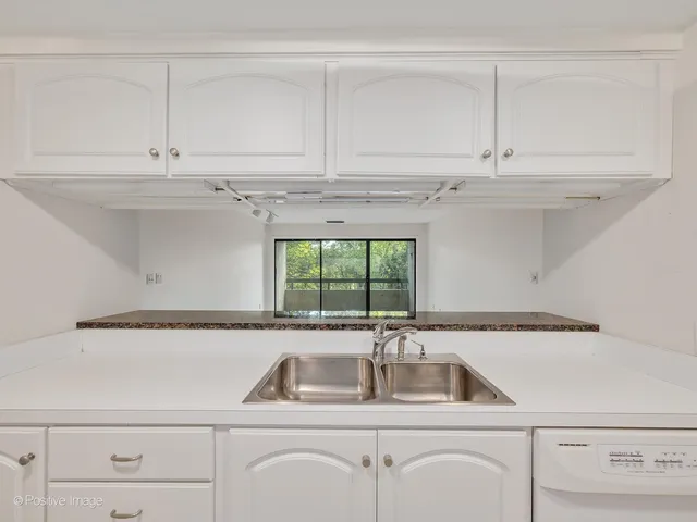 a kitchen with white cabinets and refrigerator