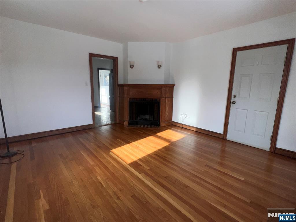 628 Valley Road Clifton, NJ 07013 - Photo 5 of 6 an empty room with wooden floor and fireplace