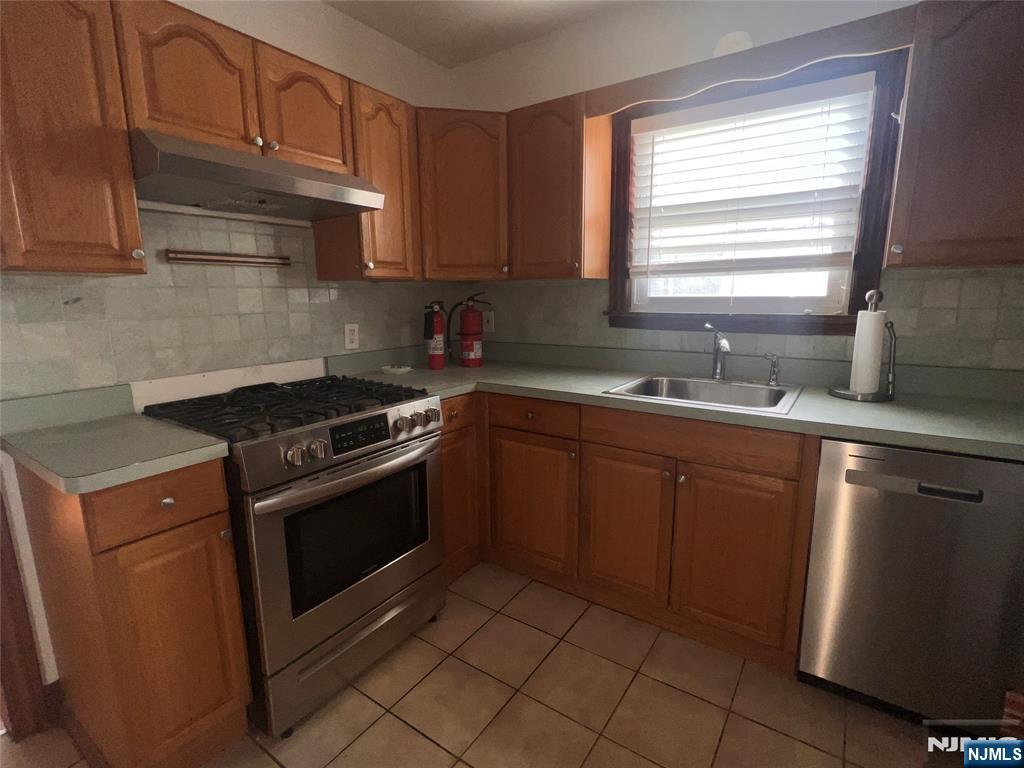 628 Valley Road Clifton, NJ 07013 - Photo 6 of 6 a kitchen with stainless steel appliances granite countertop a sink stove and cabinets