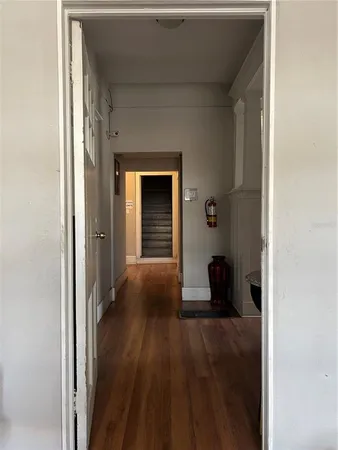 a view of a hallway with wooden floor and staircase