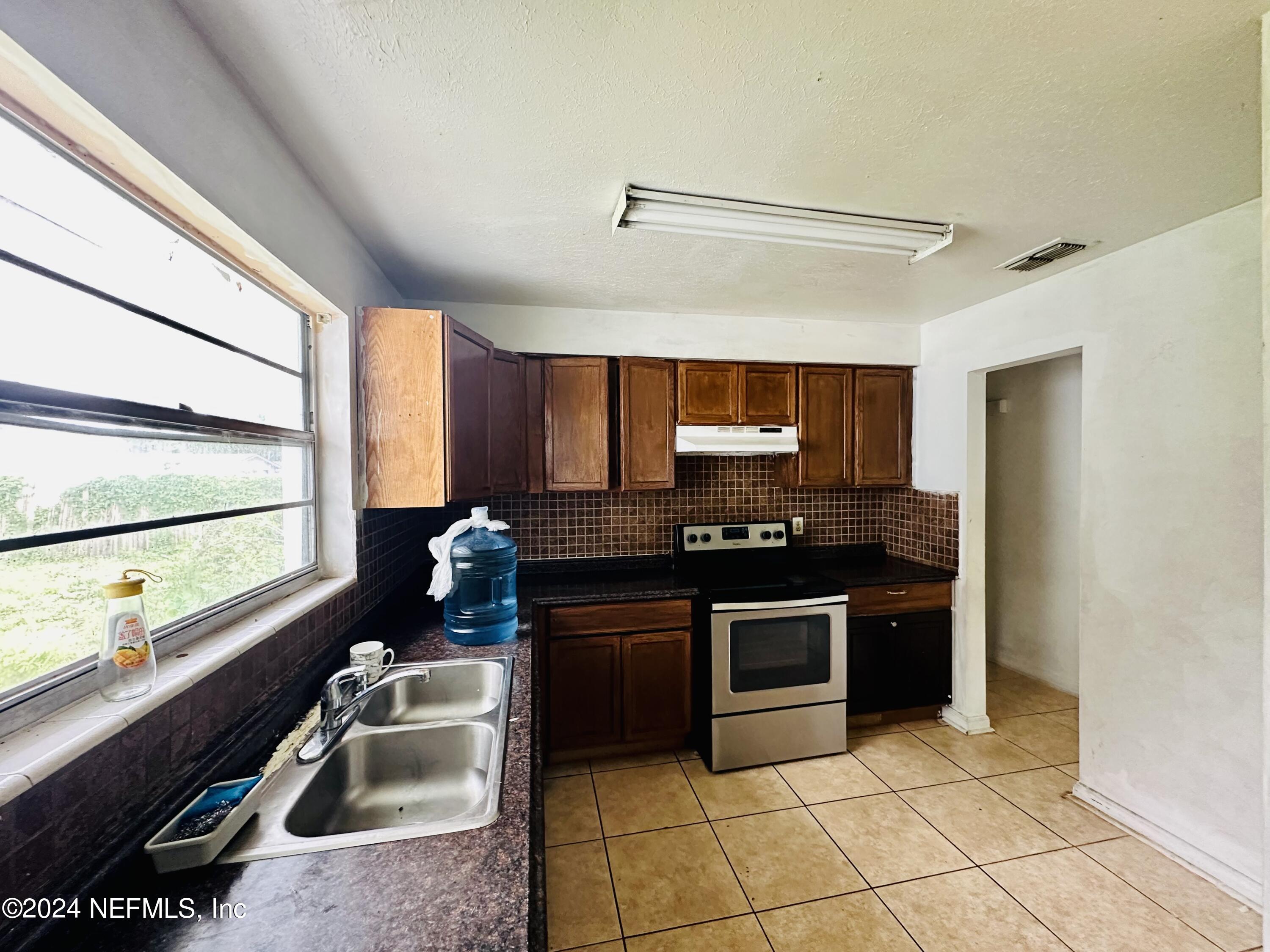 5521 Sabena Road Jacksonville, FL 32207 - Photo 11 of 13 a kitchen with stainless steel appliances granite countertop a sink stove and refrigerator