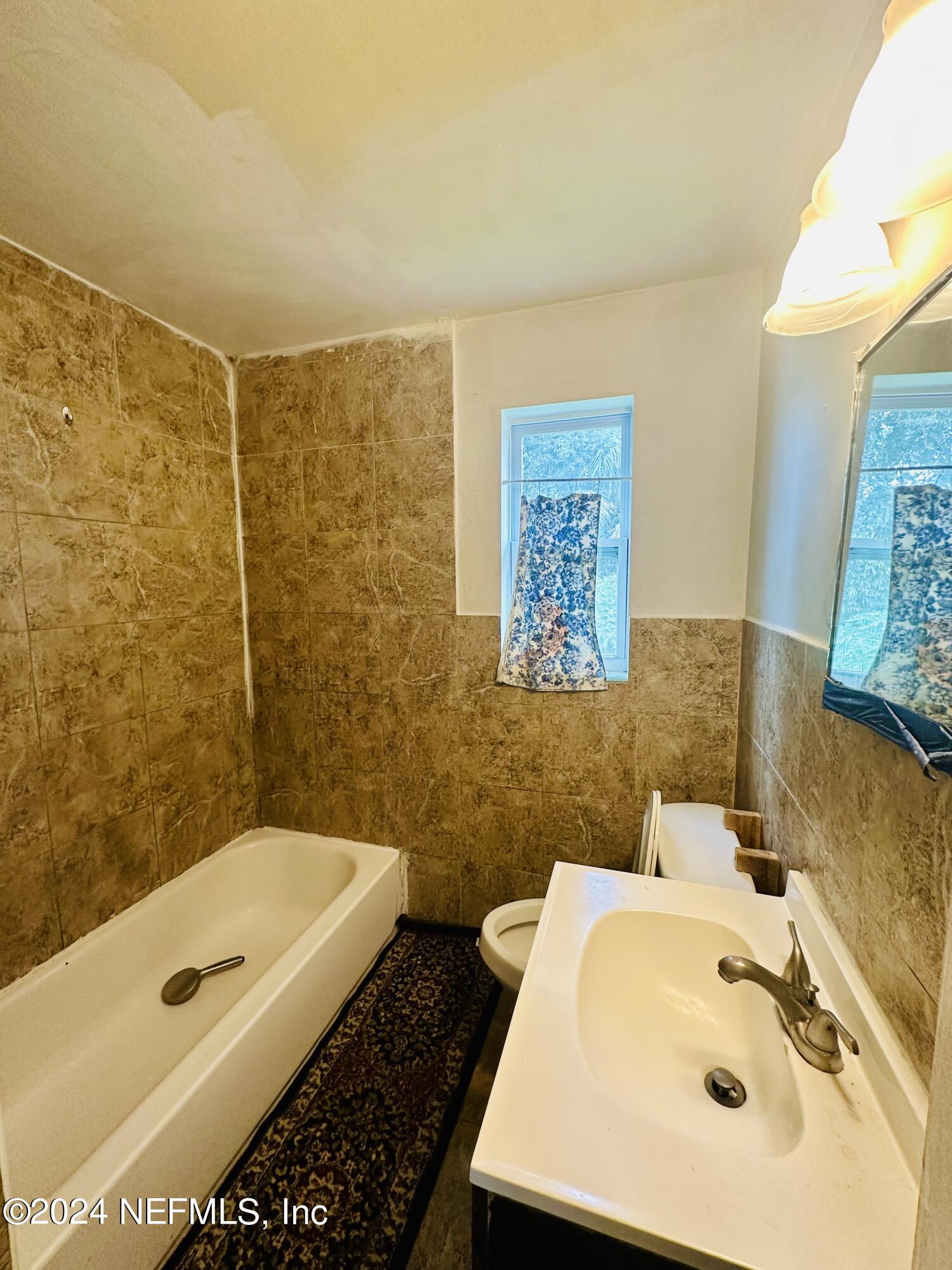 5521 Sabena Road Jacksonville, FL 32207 - Photo 7 of 13 a bathroom with a tub sink and mirror