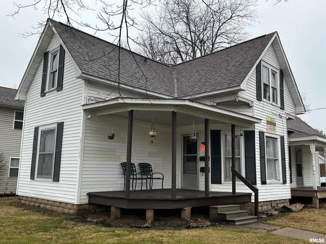 a view of a house with a small yard and wooden floor and fence