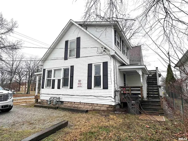 a view of a house with a yard and wooden fence